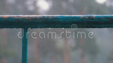在下雨的街道背景下，水滴滴在窗户、阳台或栏杆上